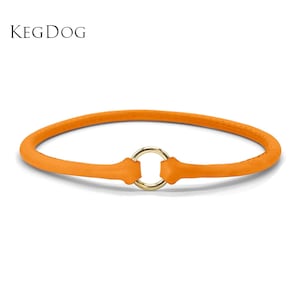 May include: An orange leather collar featuring a central gold-toned metal ring closure. The text KEGDOG is printed in black in the upper left corner. The collar has a smooth, rounded design with visible stitching along the edges of the leather band.