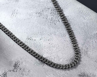 May include: A black chain necklace with small, clear cubic zirconia stones set into the links.