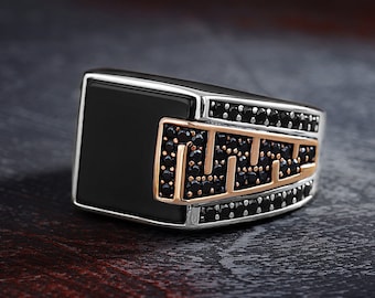 May include: A silver ring with a black onyx stone and a geometric design set with black cubic zirconia stones.