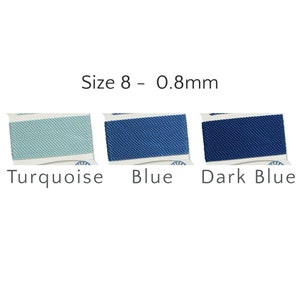 May include: Three spools of Size 8 - 0.8mm cord in turquoise, blue, and dark blue. Each spool is neatly wrapped and labeled with the color name. The cords have a textured appearance, suggesting a woven or braided construction.
