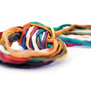 May include: A close-up of a colorful knot made from various strands of clay. The clay strands are in a variety of colors, including blue, orange, red, and white. The knot is centered on a white background.