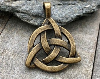 May include: Bronze-colored Celtic Triquetra pendant. The pendant features a three-pointed knot design, with a loop at the top for a chain. The pendant is made of metal and has an aged, antique finish.