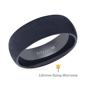 May include: A dark blue titanium ring with a textured finish. The ring has the word "TITANIUM" engraved on the inside.