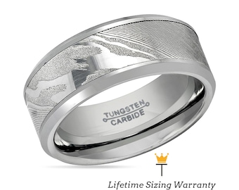 Op de afbeelding: Een zilveren ring van wolfraamcarbide met een geborstelde afwerking en een uniek patroon. De ring is gegraveerd met de woorden "Tungsten Carbide".