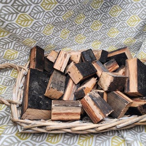 May include: A wicker basket filled with a variety of wood pieces, some are dark brown and some are light brown with visible grain.