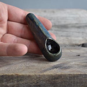 May include: A white ceramic mug with a black handle and the text "But First, Coffee" in a black, handwritten-style font. The mug is on a white surface.