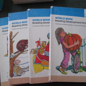 May include: Four vintage "World Book Reading Development Program" books. The covers feature illustrations of a squirrel on a tree, a carousel, and a child carrying a pumpkin. The books are labeled "Level 1 Book 1."