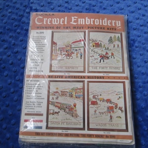 May include: A vintage Bucilla Crewel Embroidery kit featuring "Winning of the West" picture kits. The kit includes four framed embroidery designs: Pony Express, The Forty Niners, Santa Fe Railroad, and Wagon Train. The kit is sealed in plastic.