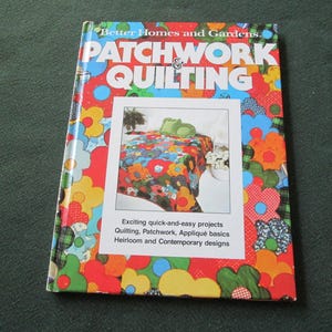 May include: A colorful book titled "Patchwork & Quilting" by Better Homes and Gardens. The cover features a vibrant floral design and an image of a quilt. Text on the cover promotes quick and easy quilting projects.