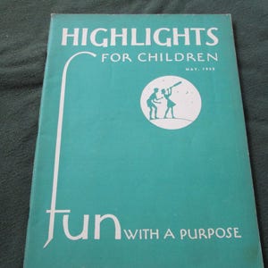May include: A vintage "Highlights for Children" magazine cover. The cover is teal with white text that reads "HIGHLIGHTS FOR CHILDREN" and "fun WITH A PURPOSE." A circular illustration depicts two figures looking through a telescope. The date "MAY, 1953" is also visible.