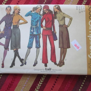 May include: Vintage Simplicity sewing pattern envelope featuring illustrations of women's fashion designs. The envelope displays various outfits in shades of purple, yellow, blue, and red. The text on the envelope includes the pattern number, size, and brand name.