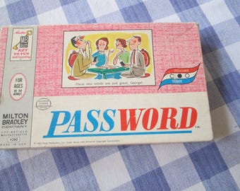 May include: A vintage "Password" board game box by Milton Bradley. The box has a pink background and a cartoon illustration of people playing the game. The game is suitable for ages 10 to adult. The game title is in large blue and red letters.