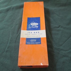 May include: An orange box with blue text that reads "Davol Quality Ice Bag Curved Throat Style". The box also includes the text "Progress since 1877 Davol Rubber Company Made in United States of America".