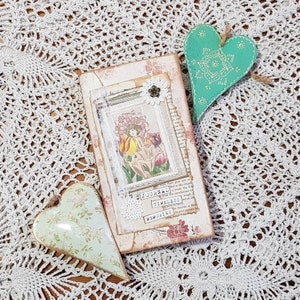Puede incluir: Un diario de estilo vintage con un diseño floral y las palabras "Journal", "Timeless" y "Memories" en la portada. El diario está rodeado de dos corazones decorativos.