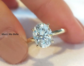May include: A gold band engagement ring with a large oval-shaped diamond.