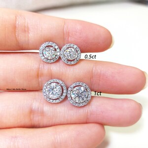 May include: Two pairs of diamond halo stud earrings. The smaller pair has 0.5ct diamonds and the larger pair has 1ct diamonds.