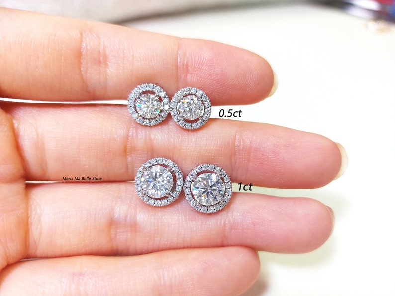May include: Two pairs of diamond halo stud earrings. The smaller pair has 0.5ct diamonds and the larger pair has 1ct diamonds.