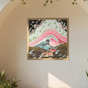 Japanese inspired wave and blossom landscape paper collage art print in a gold frame displayed in a tranquil yoga studio with wooden floors, meditation cushions, and lush greenery.