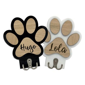 May include: Two wooden paw print hooks, one black and one white, with the names "Hugo" and "Lola" engraved on them.