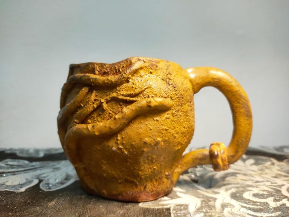 Hand-sculpted root/vine texture wraps the whole cup — this looks like something dug out of a forest floor, not thrown on a pottery wheel, and no two are alike.