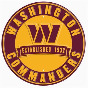 Puede incluir: Un letrero metálico redondo con el logotipo de los Commanders de Washington en burdeos, dorado y amarillo. Se muestra el nombre del equipo y "Established 1932". El letrero tiene dos pequeños agujeros para colgar.