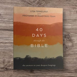 May include: A book cover with a gradient background of orange, brown, and green. The title "40 DAYS through the BIBLE" is prominently displayed in white. The author's name, Lysa TerKeurst, and the Proverbs 31 Ministries Team are also featured.