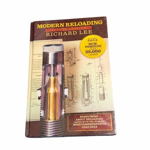 Pode incluir: Um livro intitulado "Modern Reloading Second Edition" de Richard Lee. A capa apresenta um diagrama de uma bala e um estojo, com o texto "New Powders Over 38,000 Loads". O livro fornece dados de carregamento abrangentes.