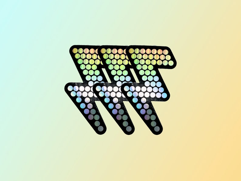 May include: Three black lightning bolt stickers with a holographic, rainbow-colored dot pattern. The stickers are arranged in a row, with a gradient background of light blue to yellow.