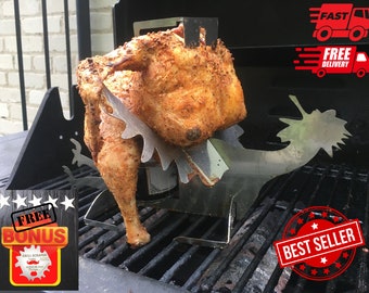 Könnte beinhalten: Ein Edelstahl-Hähnchen-Bräter mit einem einzigartigen Design, das für gleichmäßiges Garen sorgt. Der Bräter befindet sich auf einem schwarzen Grill mit einem Hähnchen darin. Das Hähnchen ist goldbraun und perfekt gegart. Der Bräter ist eine großartige Möglichkeit, ein ganzes Hähnchen auf dem Grill zu garen.