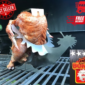 Peut inclure: Un rôtissoire à poulet en acier inoxydable avec un poulet dessus. Le rôtissoire est sur un barbecue noir. Le poulet est assaisonné d'épices et est en train de cuire. Le rôtissoire a un design unique qui permet de cuire le poulet uniformément. Le rôtissoire est un excellent moyen de cuire un poulet entier sur le barbecue.