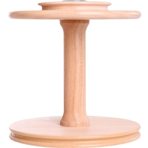 May include: A wooden yarn swift, featuring a round base, a central stem, and a circular top. The natural wood finish highlights the grain. The swift is designed to hold yarn for knitting or crocheting projects.