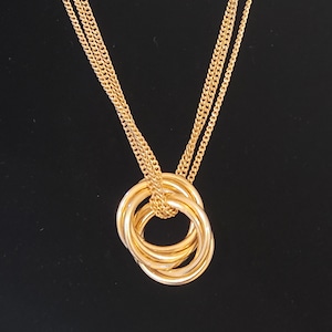 May include: A gold necklace with a pendant made of four interlocking rings.