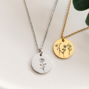 May include: Two silver necklaces with round pendants. One pendant features a single rose, the other features three different flowers.