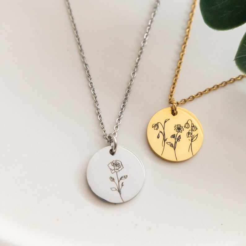 May include: Two silver necklaces with round pendants. One pendant features a single rose, the other features three different flowers.