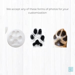 May include: Three different ways to capture your pet's paw print for a custom keepsake. A white clay paw print, a black ink paw print, and a photo of a dog's paw.