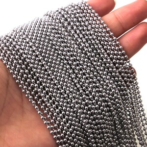 May include: A silver ball chain necklace with small, round links. The chain is made of metal and has a polished finish.