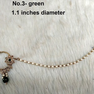 May include: A gold nose ring with a green stone and white pearl chain. The ring is 1.1 inches in diameter. No. 3 - green