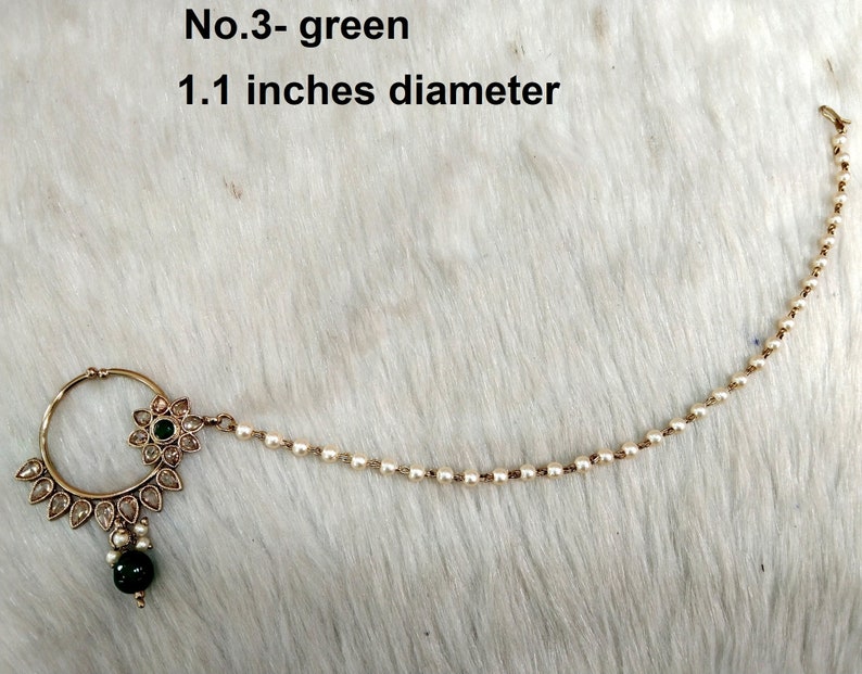 May include: A gold nose ring with a green stone and white pearl chain. The ring is 1.1 inches in diameter. No. 3 - green