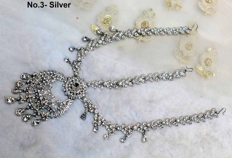 Peut inclure: Coiffe argent&eacute;e orn&eacute;e de strass &eacute;tincelants. Le design comprend un motif floral central, des d&eacute;tails en forme de goutte et deux pi&egrave;ces lat&eacute;rales. Le texte "No.3- Silver" est visible. Id&eacute;al pour les occasions sp&eacute;ciales.
