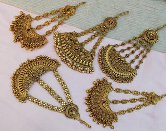 May include: An assortment of antique gold-colored hair accessories. Each piece features intricate floral and geometric patterns, with dangling chains and decorative elements. The pieces are designed to be worn on the head and are likely for special occasions.