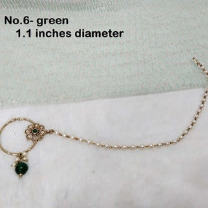 May include: Gold nose ring with a green stone and a chain of white pearls. The ring is 1.1 inches in diameter. No. 6 - green.