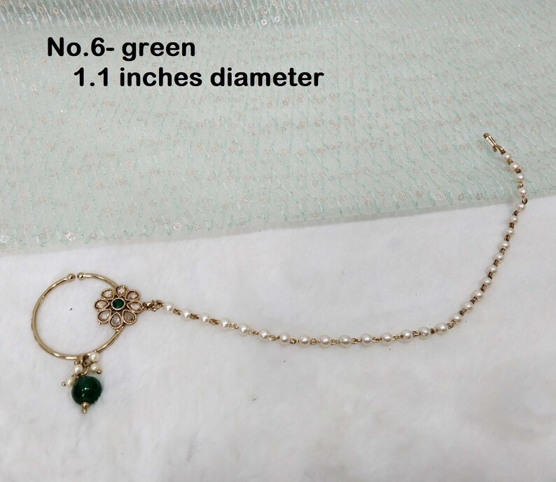 May include: Gold nose ring with a green stone and a chain of white pearls. The ring is 1.1 inches in diameter. No. 6 - green.