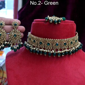 May include: A gold choker necklace with green and white beads, a matching pair of earrings with green stones, and a small green and white bead necklace. The text "No.2 - Green" is visible in the image.