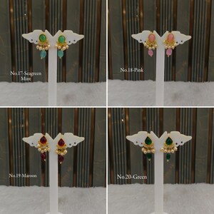 May include: Four pairs of gold-tone drop earrings displayed on white stands. Each pair features a central oval stone, small gold accents, and dangling beads. The sets are labeled No.17-Seagreen Mint, No.18-Pink, No.19-Maroon, and No.20-Green.