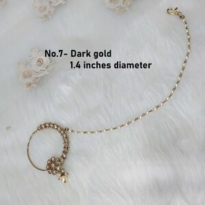May include: A gold nose ring with a pearl drop and a chain. The ring is decorated with small white stones. The chain is 1.4 inches in diameter. No.7 - Dark gold.