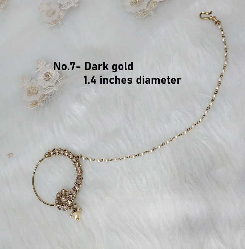 May include: A gold nose ring with a pearl drop and a chain. The ring is decorated with small white stones. The chain is 1.4 inches in diameter. No.7 - Dark gold.