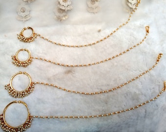 May include: Four gold nose rings with pearl chains. The nose rings are different sizes and have a cluster of pearls on the ring. The chains are made of small gold beads with a pearl on each bead.