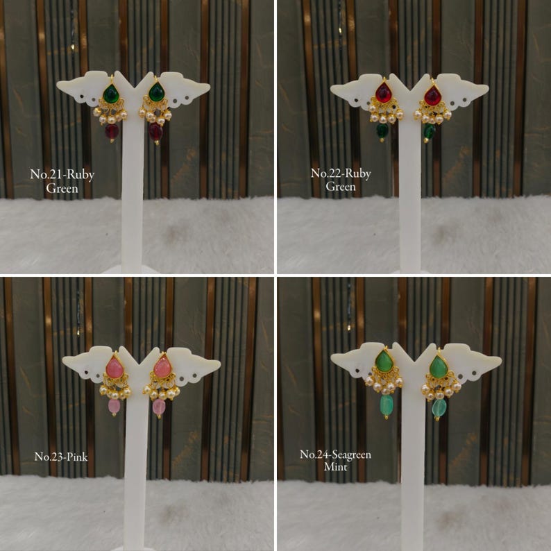 May include: Four pairs of gold-toned drop earrings displayed on white stands. Each pair features a teardrop-shaped stone in green, ruby, pink, or seagreen, accented with small white beads and gold filigree details. Text labels identify each set.