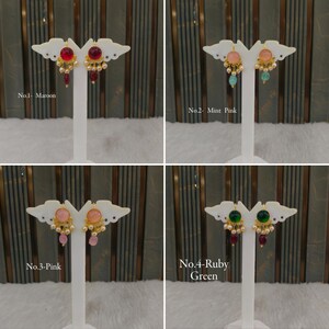 May include: Four pairs of drop earrings displayed on white stands. No. 1 features maroon stones, No. 2 has mint and pink stones, No. 3 displays pink stones, and No. 4 shows ruby and green stones. Each earring includes gold-tone metal and small pearls.