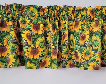 Könnte beinhalten: Eine Gardine mit Sonnenblumen- und Vogelmotiv. Die Gardine ist aus dunkelgrünem Stoff mit gelben Sonnenblumen und kleinen braunen Vögeln. Die Gardine hat einen gekräuselten Rand.
